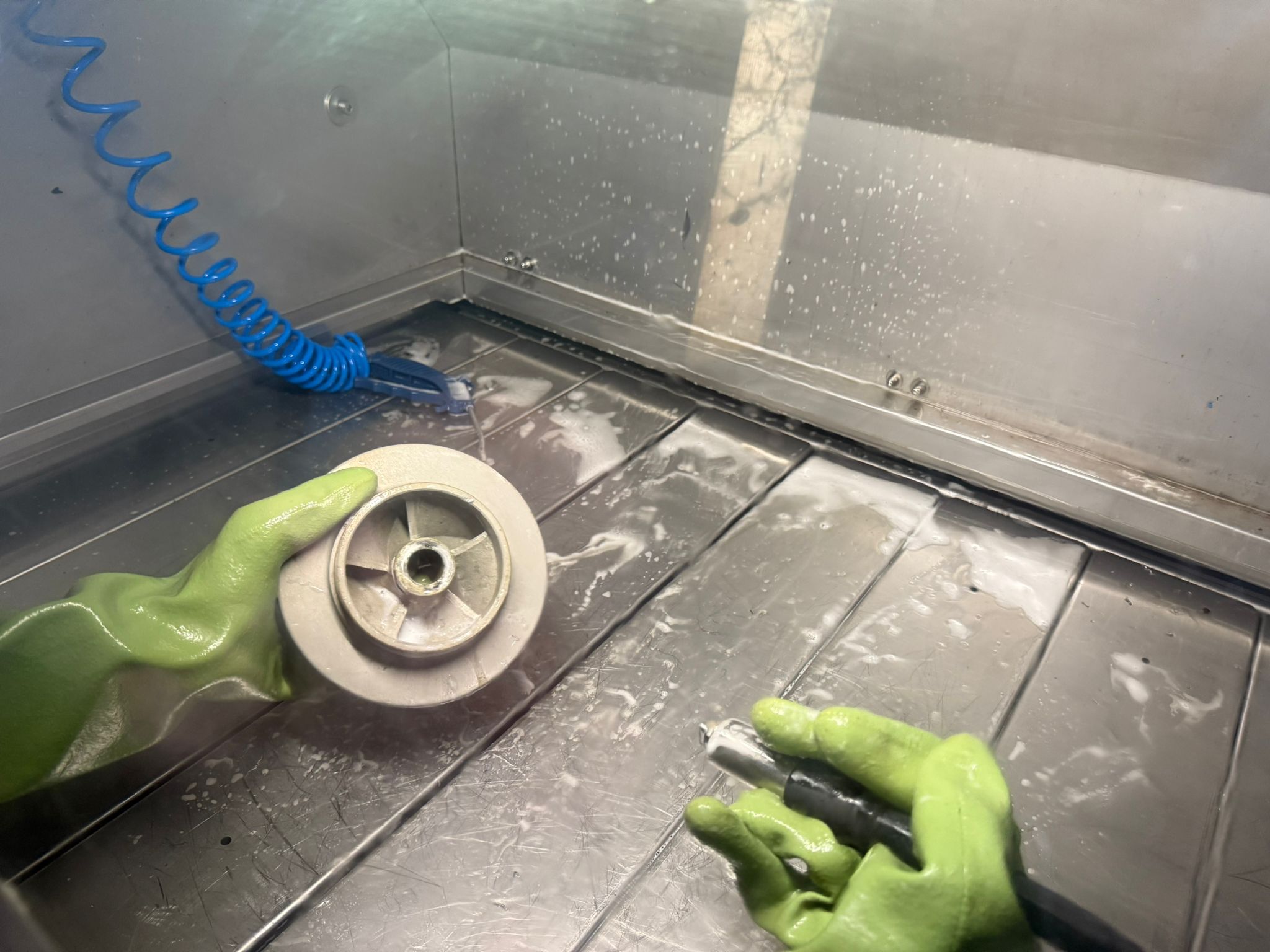 Mitarbeiter bei der Reinigung von Pumpenteilen während laufender Reparatur